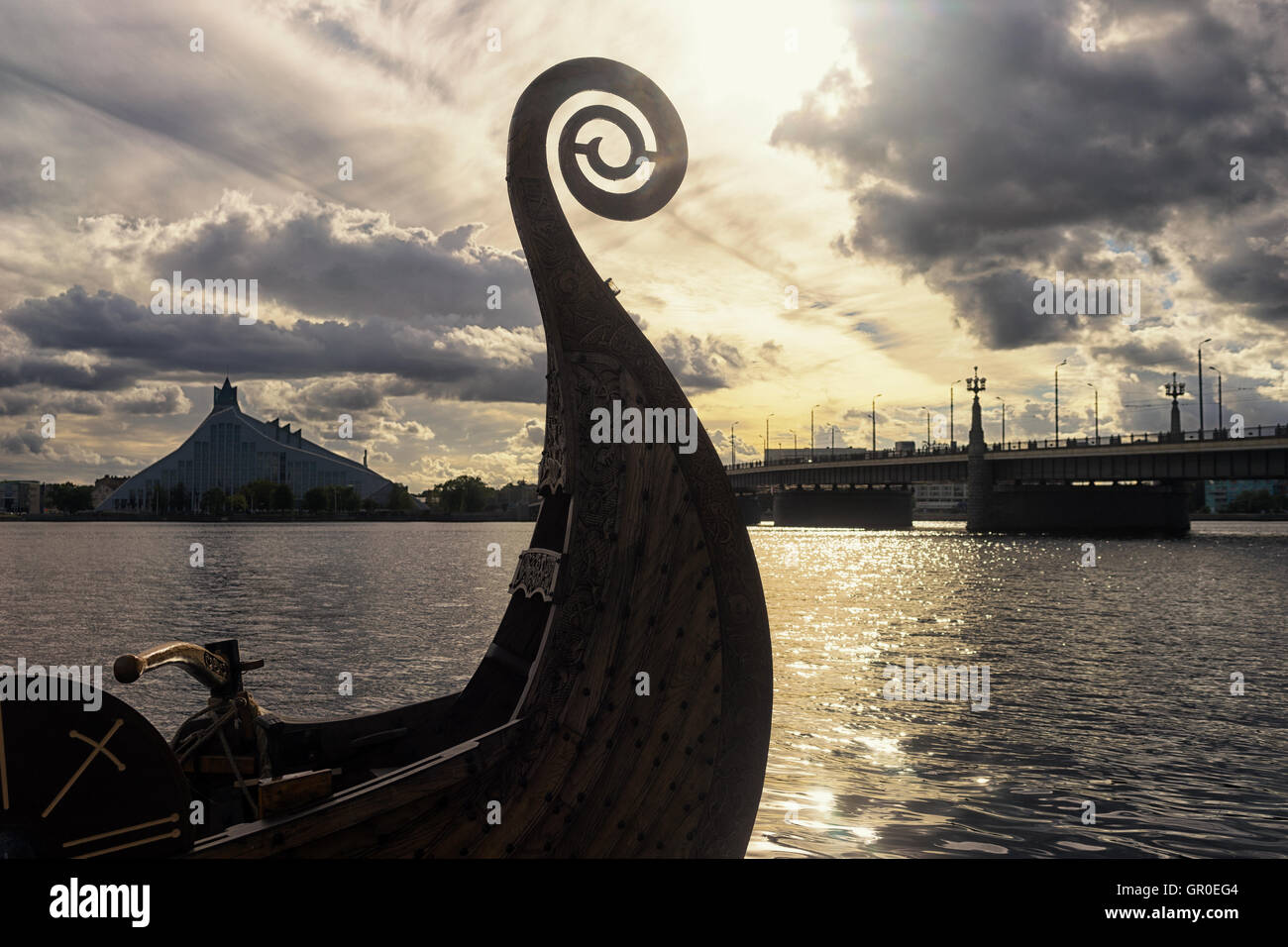 Nose Viking boat on the River Daugava on the background of the Latvian National Library and the Stone Bridge Stock Photo