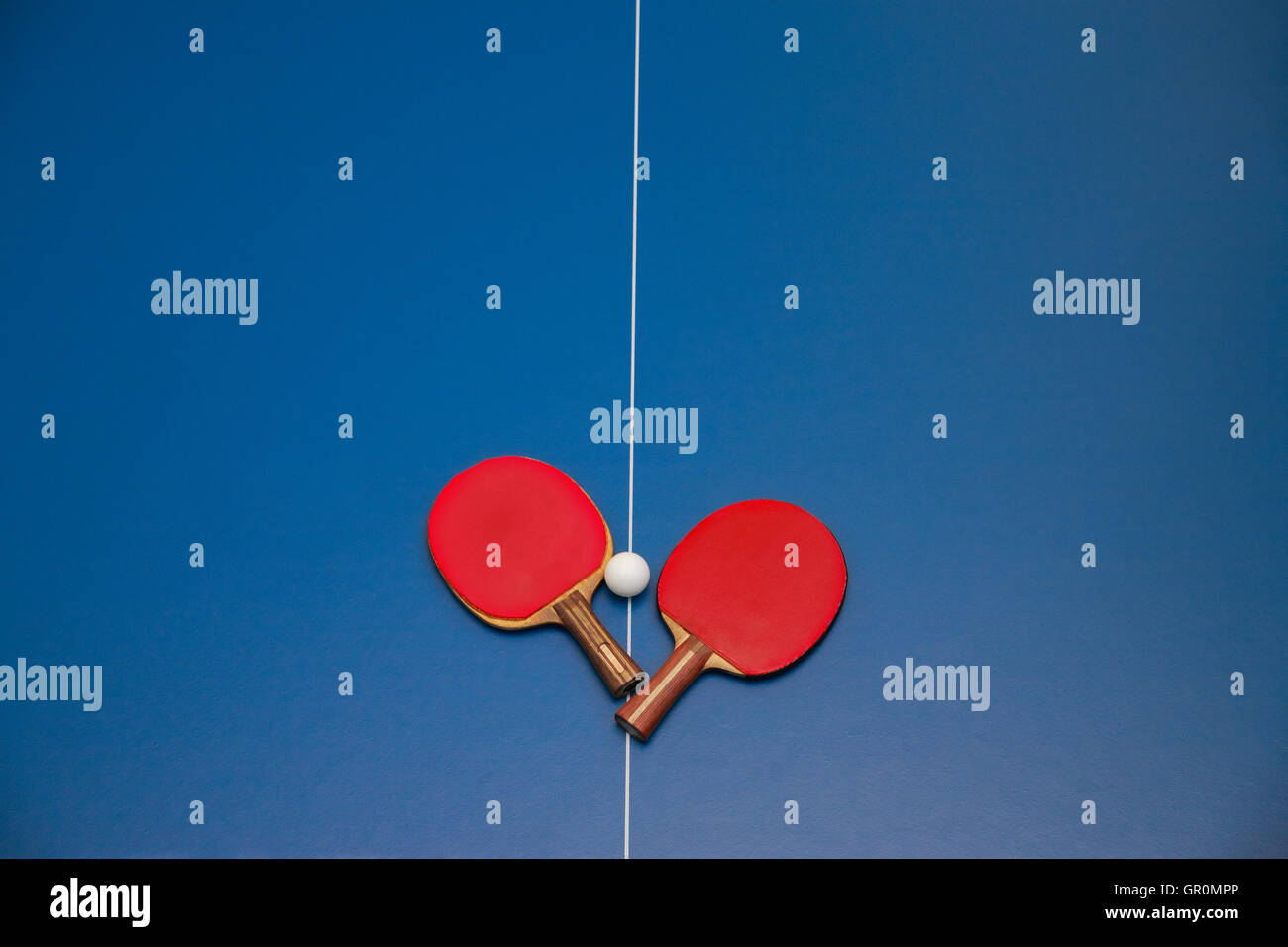 Rackets for table tennis of red color and a ball on a tennis table, view from above Stock Photo