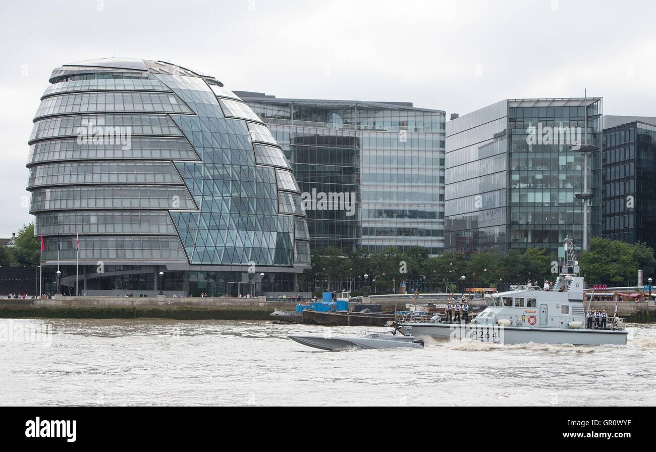 The Maritime Autonomy Surface Testbed (MAST), an unmanned surface vessel (centre) and its escort HMS Archer (right) pass City Hall as the MAST is tested on the River Thames, London, as part of preparations for the Royal Navy's 'Unmanned Warrior' test program this autumn. Stock Photo