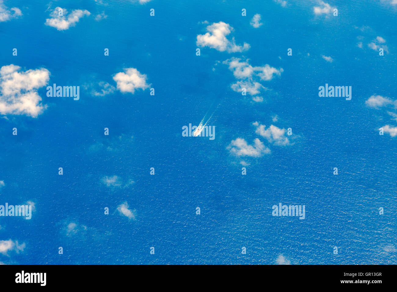 Mediterranean Sea view from airplane above the clouds with cargo ship Stock Photo