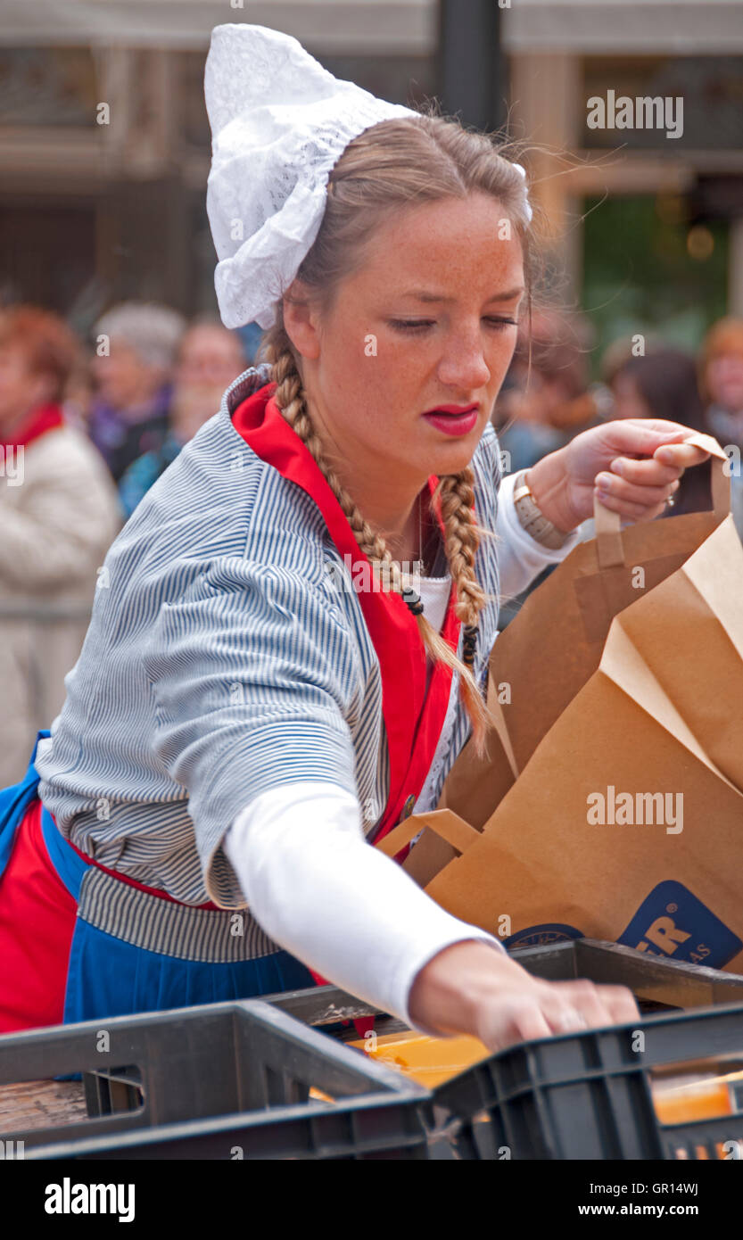 A 'cheese girl:' in a traditional costume sells samples at the Alkmaar Cheese Market, Holland Stock Photo