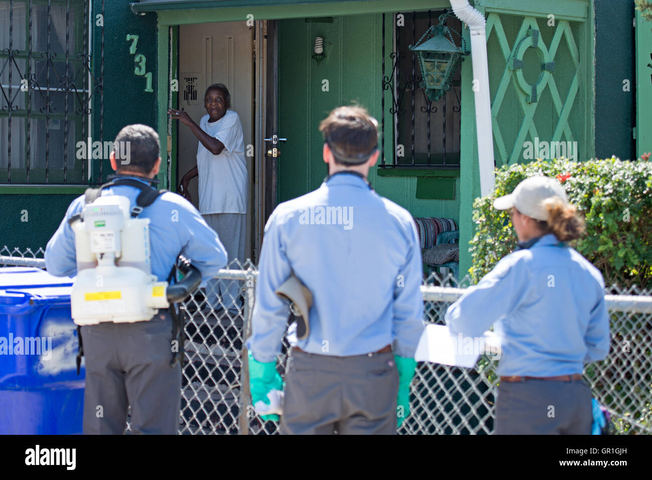 San Diego, California, USA 06th September 2016 - County of San Diego vector control technicians talk with a local resident before spraying her property in the Mt. Hope neighborhood of San Diego. The spraying is the result of a travel-related Zika case in the area. Credit:  Craig Steven Thrasher/Alamy Live News Stock Photo