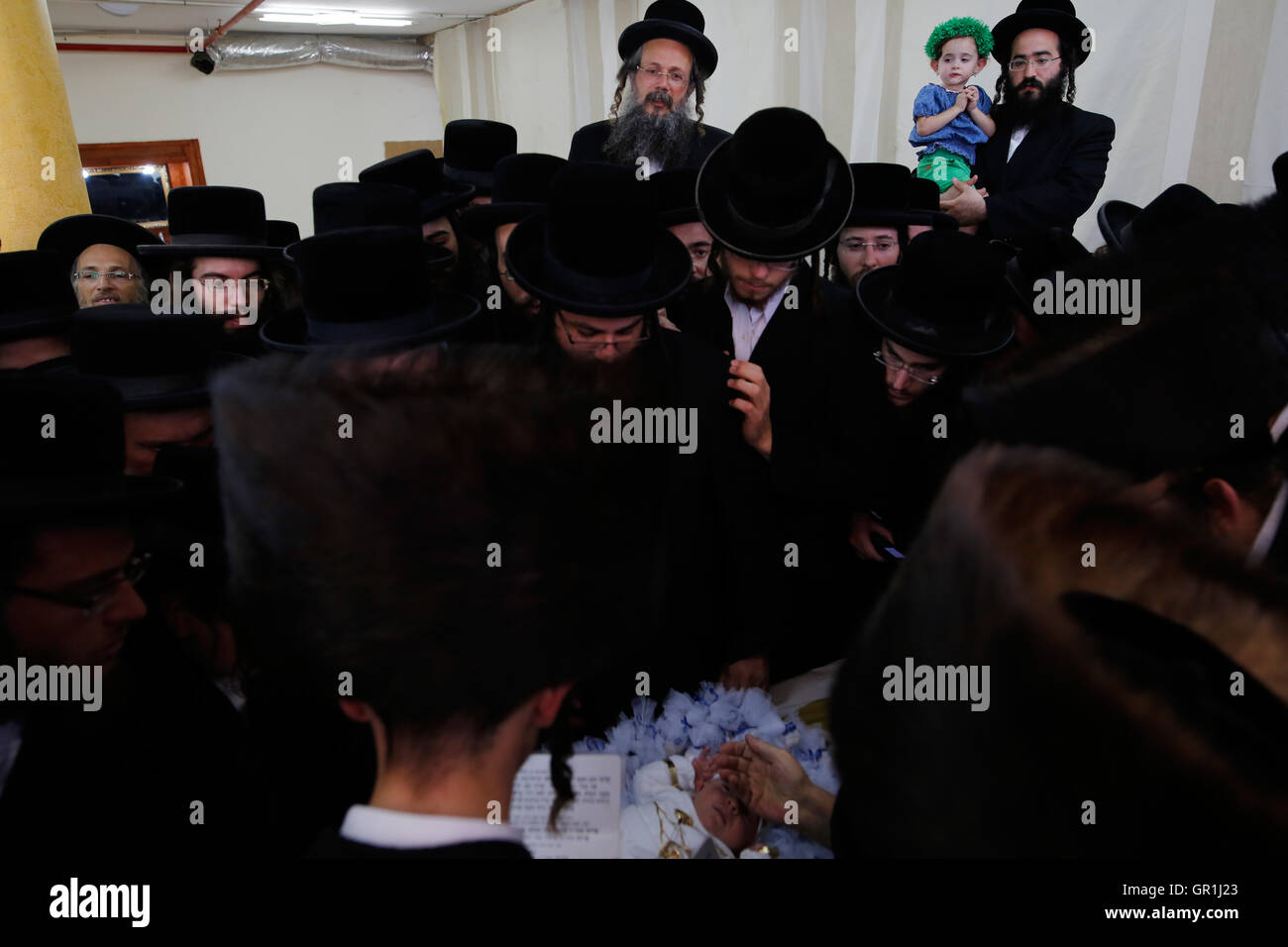(160907) -- REHOVOT, Sept. 7, 2016 (Xinhua) -- Ultra orthodox Jewish men of the Kretchnief Hasidic sect bless a thirty-day-old infant during the 'Pidyon Haben' ceremony at a synagogue in Rehovot, 30 km south of Tel Aviv, Isreal, Sept. 6, 2016. The Pidyon Haben, or redemption of the first-born son, is a mitzvah in Judaism whereby a Jewish firstborn son is redeemed by use of silver coins from his birth-state of sanctity.  (Xinhua/Gil Cohen Magen) Stock Photo