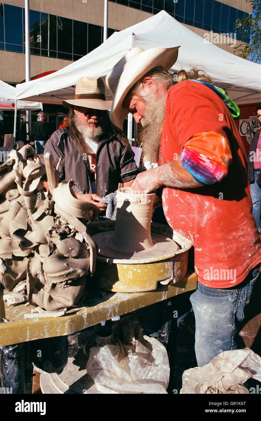 Two colorful artisans practicing their craft at an arts fair in