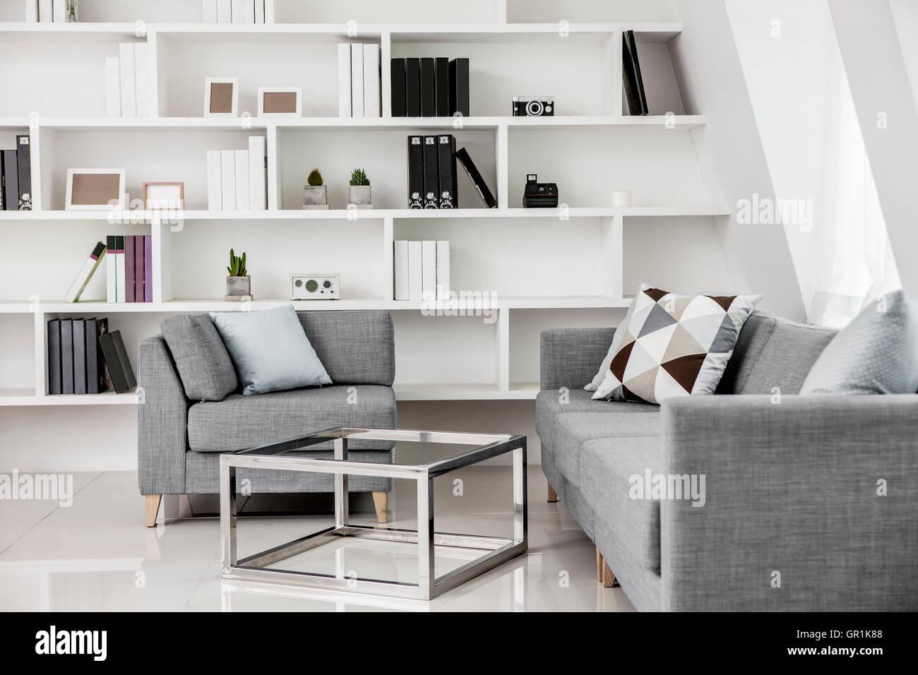 Interior with modern table and sofas against bookcases Stock Photo