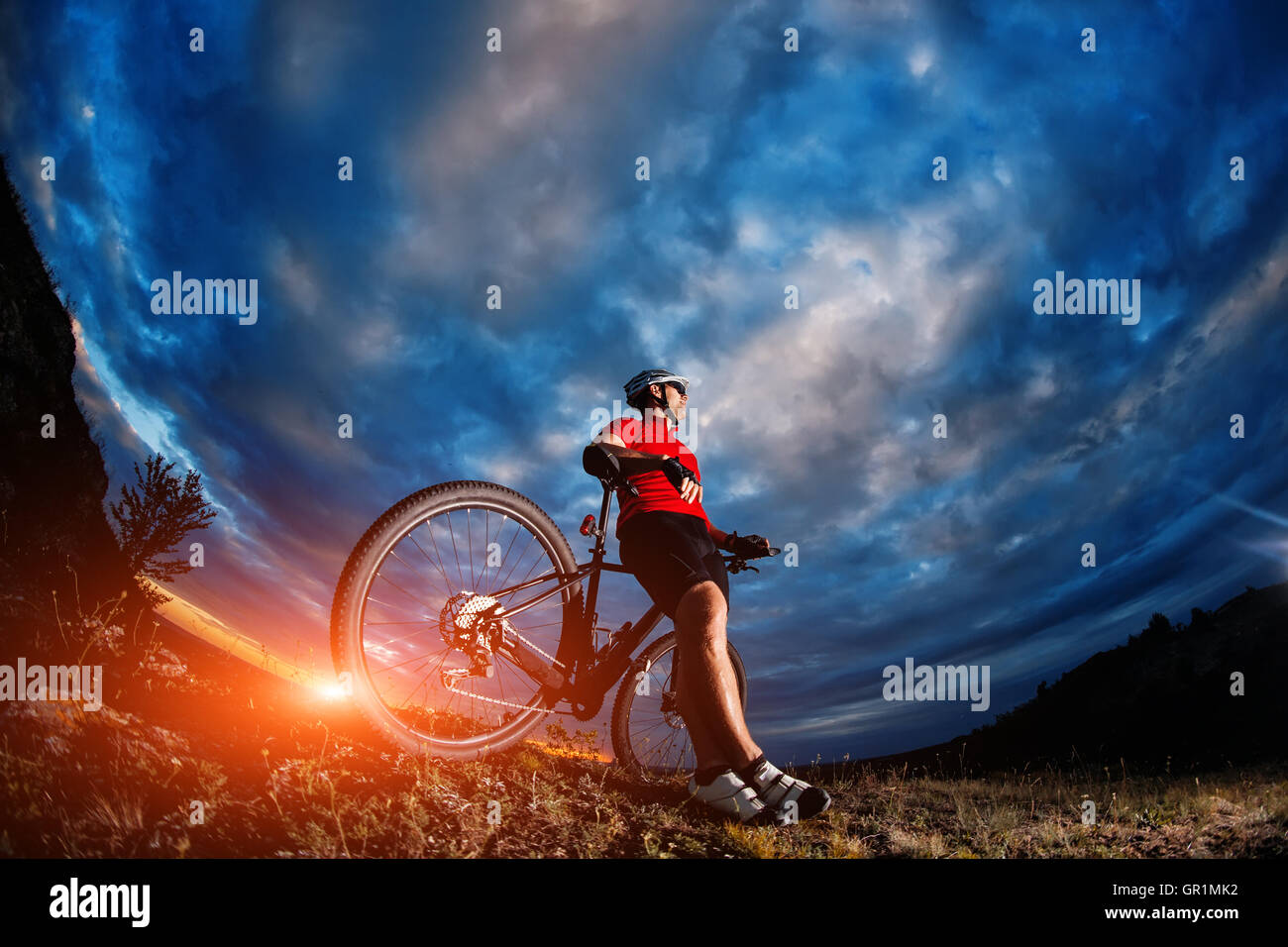 mountain bicycle rider on the hill with sunrise background Stock Photo
