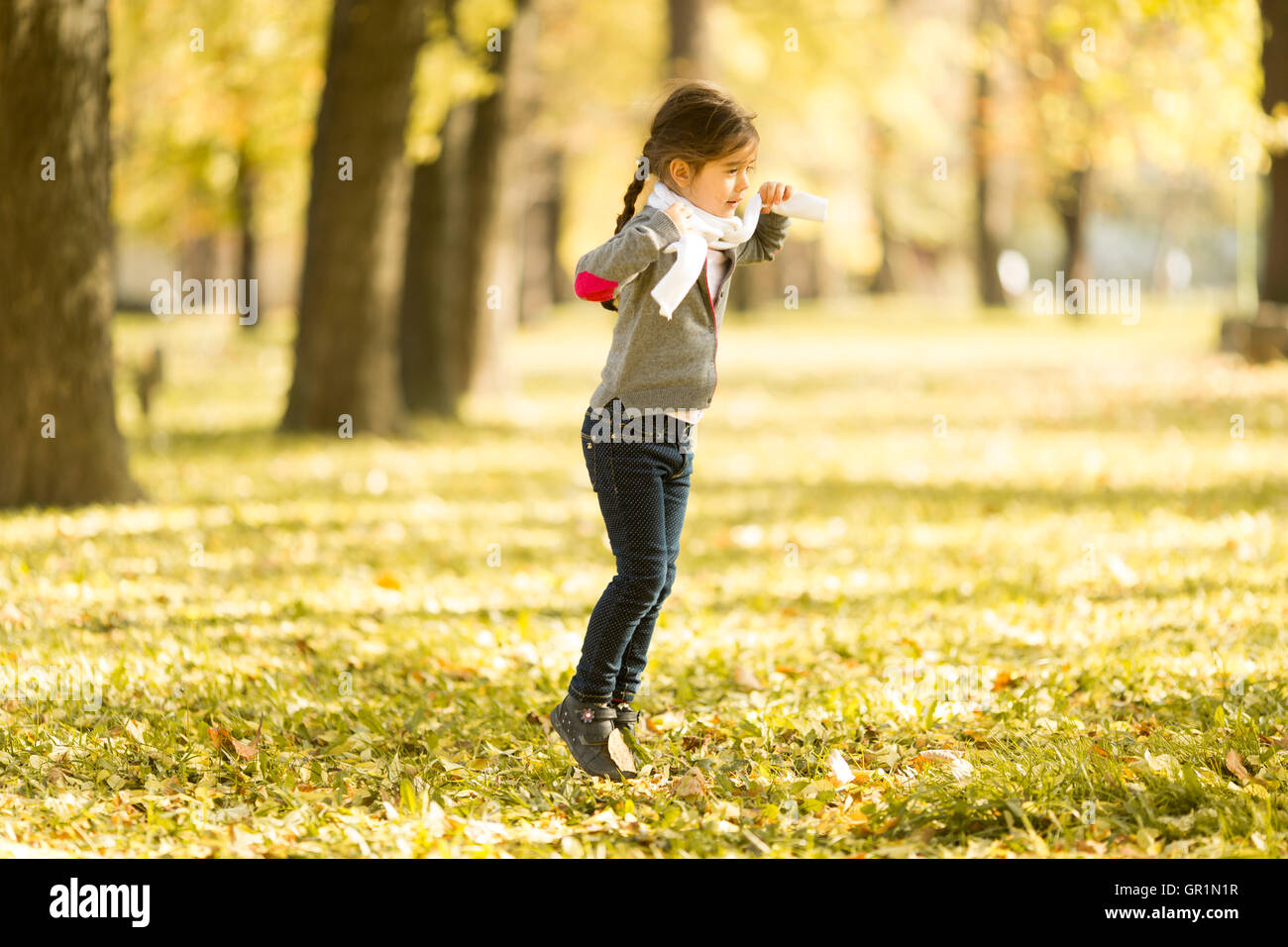 Cute little girl in the park at autumn Stock Photo - Alamy