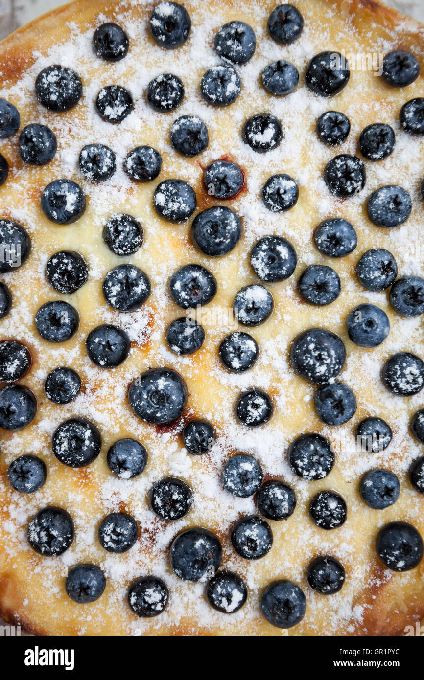 Close up overhead of blueberry pie. Sugar powder covered dough and cream Stock Photo
