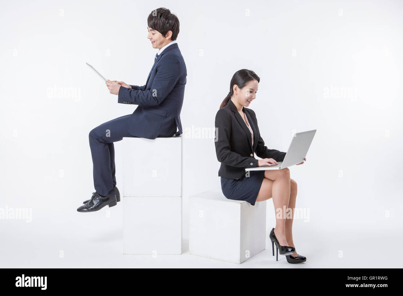 Smiling business people sitting working Stock Photo - Alamy