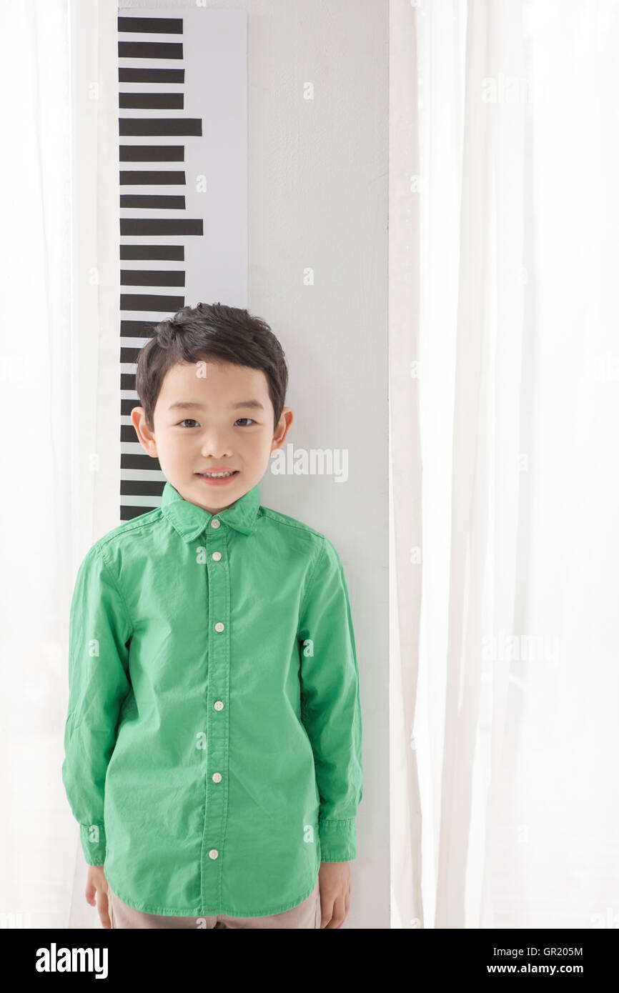 Smiling boy measuring his height Stock Photo