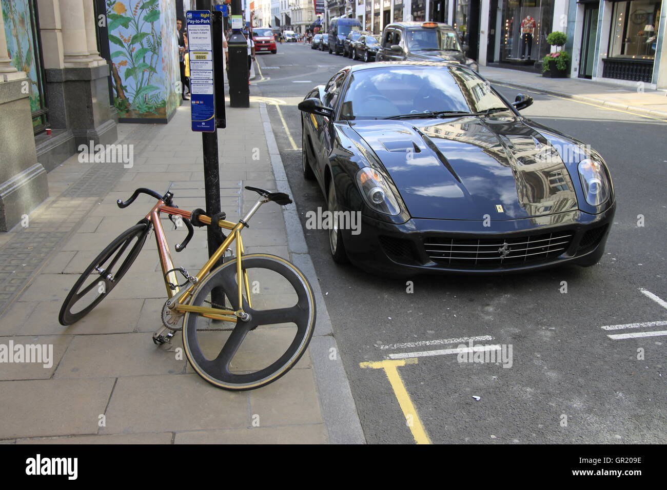 Ferrari and bicycle next to each other on Bond Street, London W1. Different modes of transport for different pockets, luxury and Stock Photo