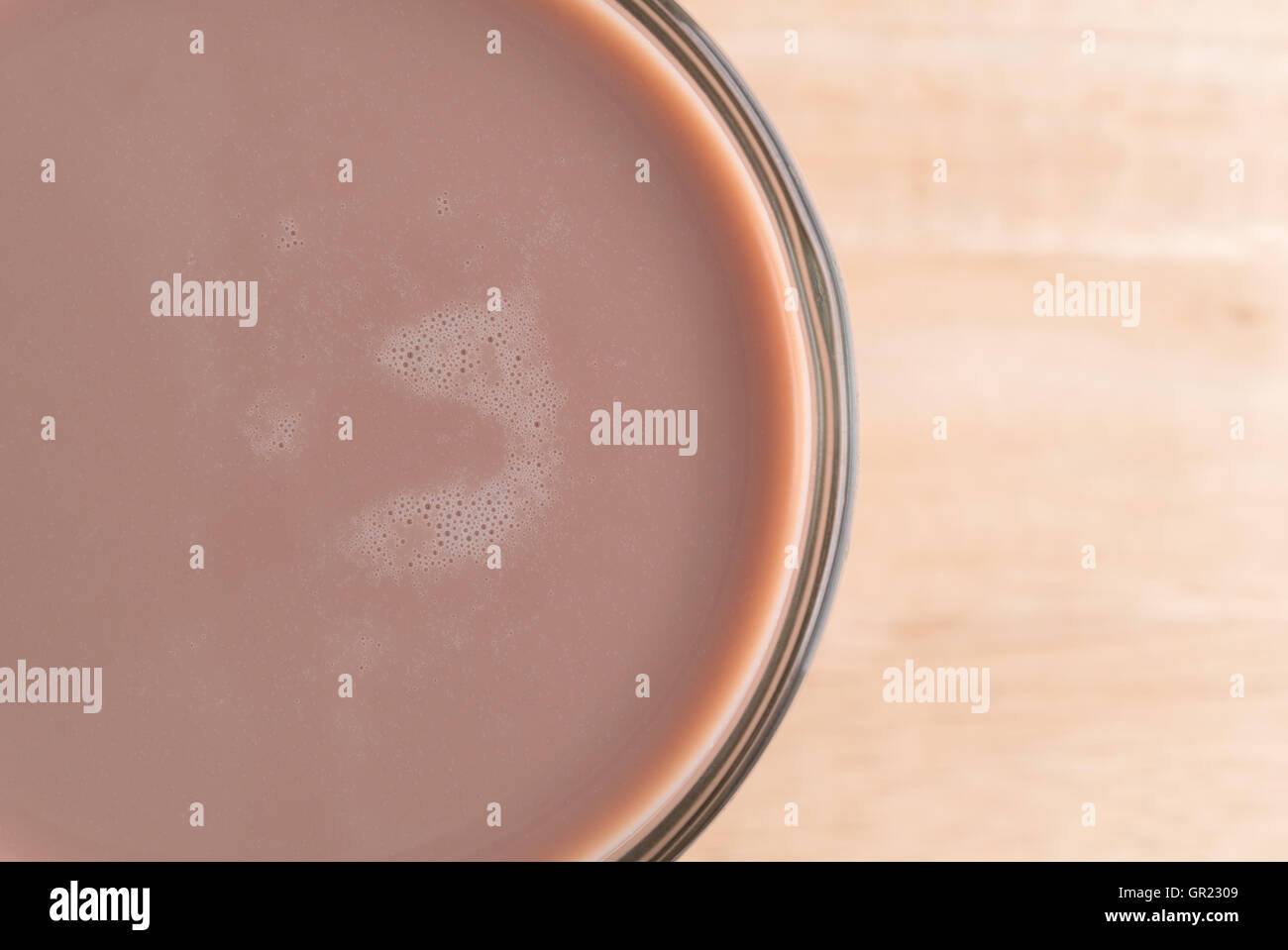 Top close view of a glass of chocolate milk on a wood table. Stock Photo