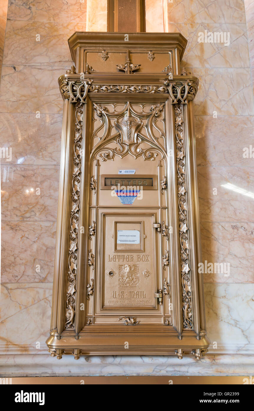 Ornate gold metal letter post box in the interior of lobby in the landmarked Woolworth Building, New York. Stock Photo
