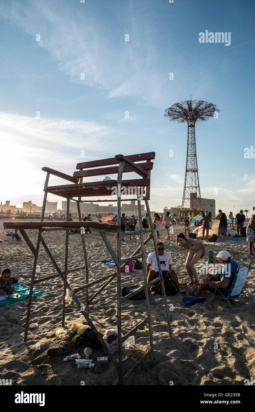 Empty old wooden lifeguard chair on Coney Island beach with the Parachute Jump in the background Stock Photo