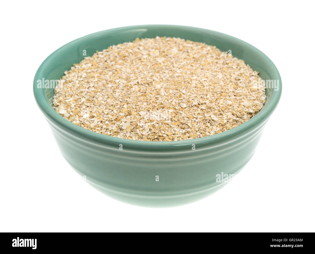 Dry oat bran hot cereal in a green bowl isolated on a white background