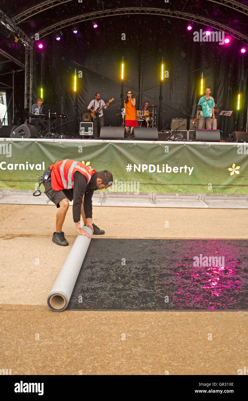 The dance-floor being rolled up during a concert at the Paralympic Day Liberty Festival, due to rain. Stock Photo