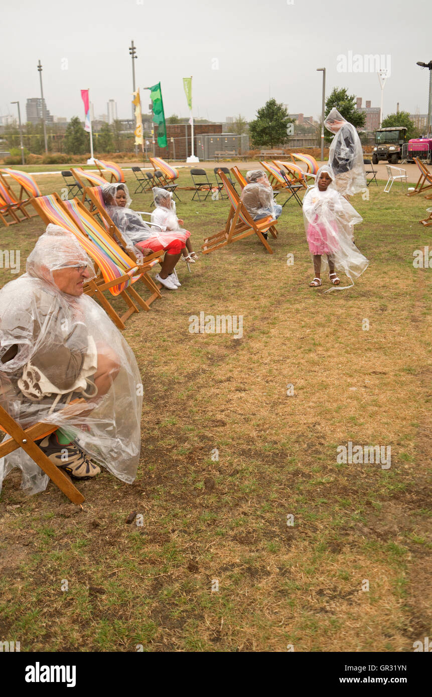 An audience in rain ponchos at the National Paralympics Day Liberty Festival in Olympic Park, London. Stock Photo