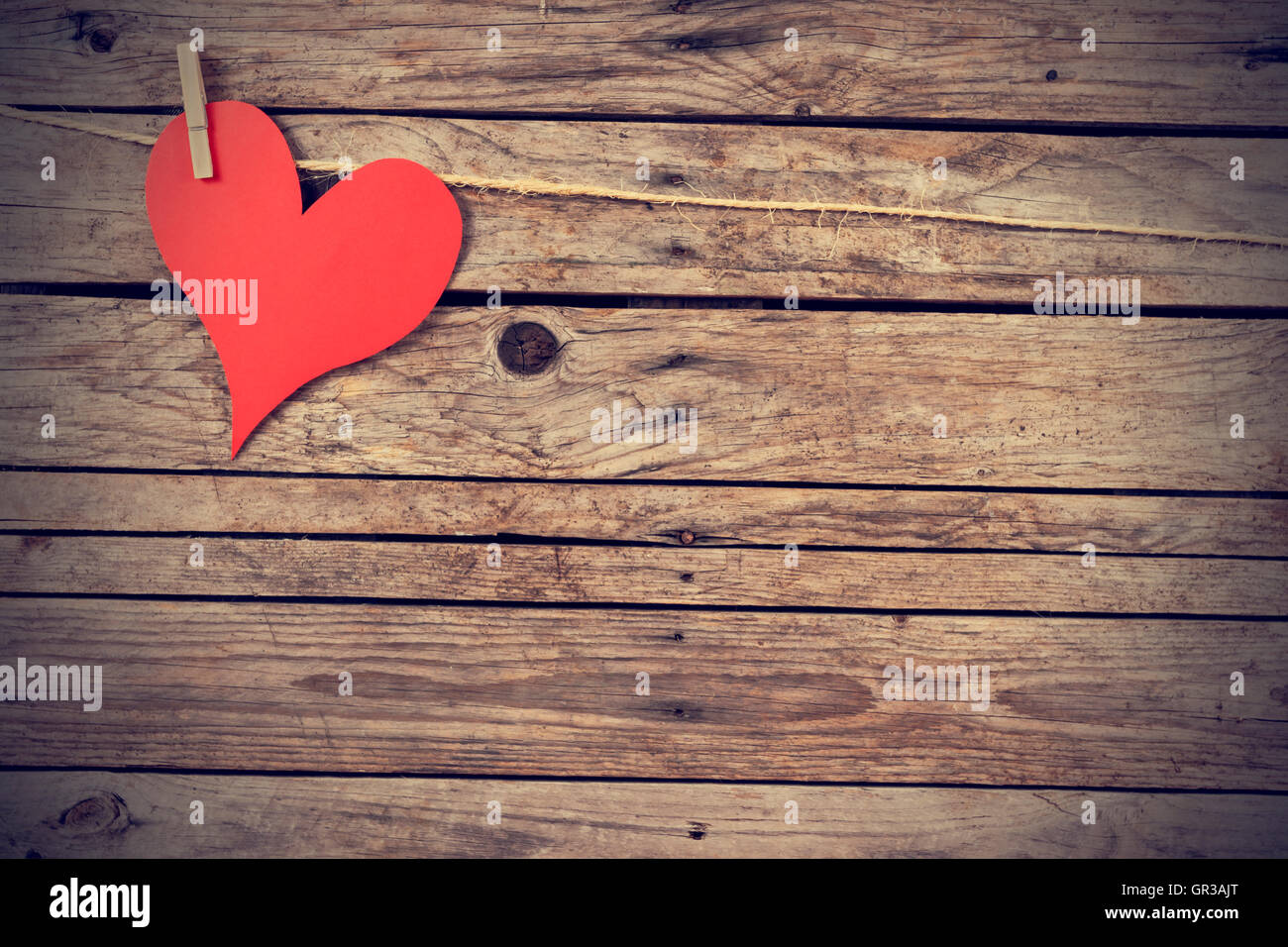 Paper heart hanging from a rope with wooden background Stock Photo - Alamy