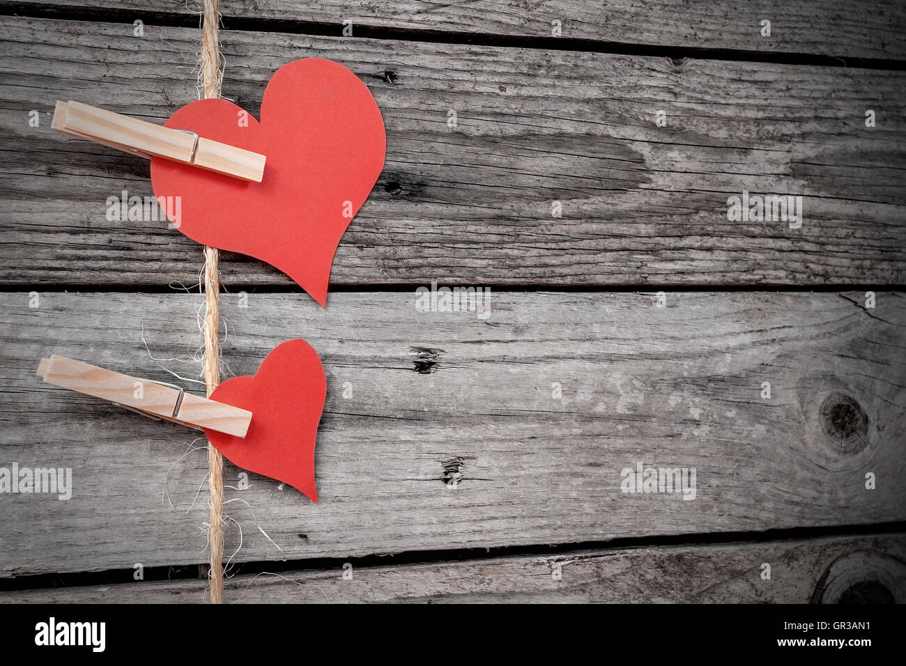 Two paper hearts hanging from a rope with wooden background Stock Photo ...