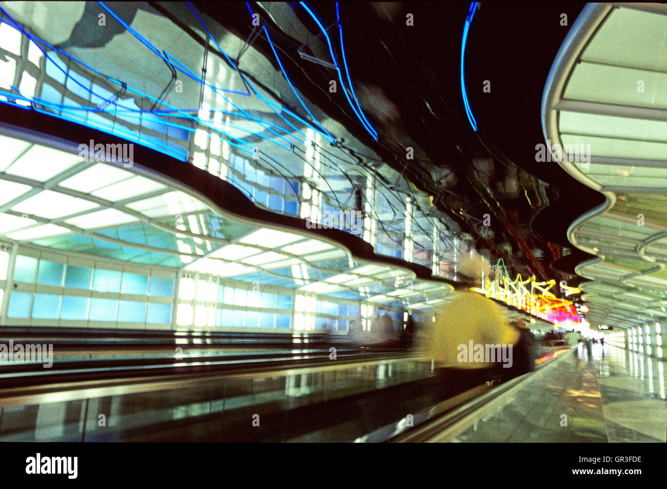 A time-lapse exposure of a moving walkway in Chicago's O'Hare Airport captures the hurried nature of airline travel. Stock Photo