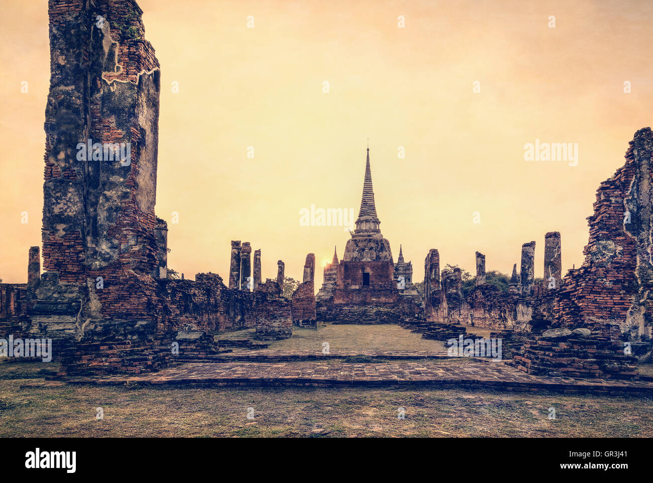Vintage style add texture effect, ancient ruins and pagoda of Wat Phra Si Sanphet old temple famous attractions during sunset Stock Photo