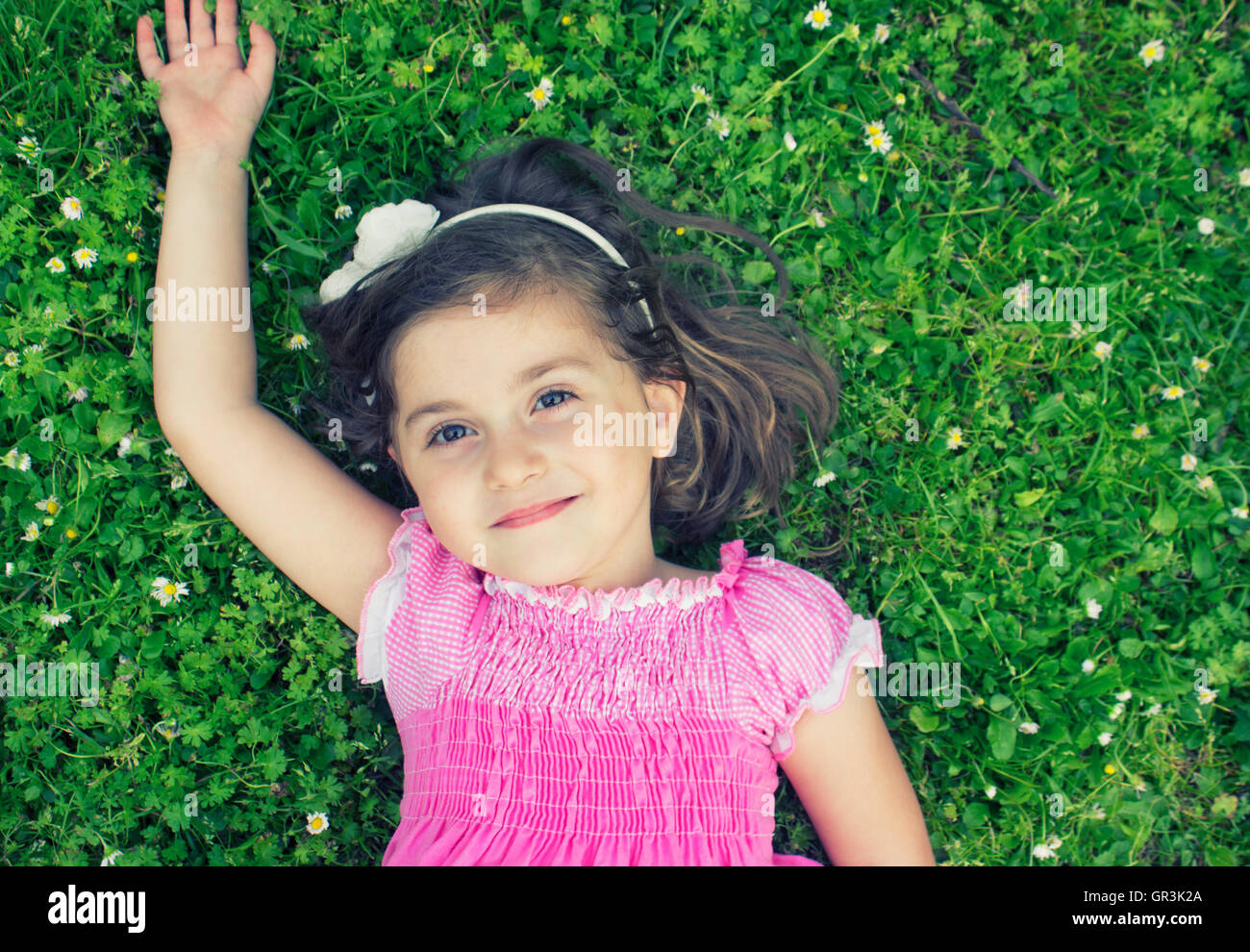 Little girl laying in the grass on a summer day Stock Photo - Alamy