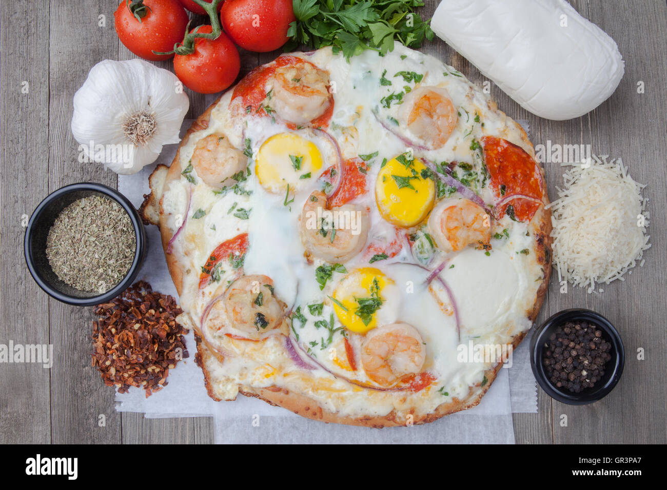 Egg pizza with fresh mozzarella and ingredients tomatoes shrimp green pepper Stock Photo