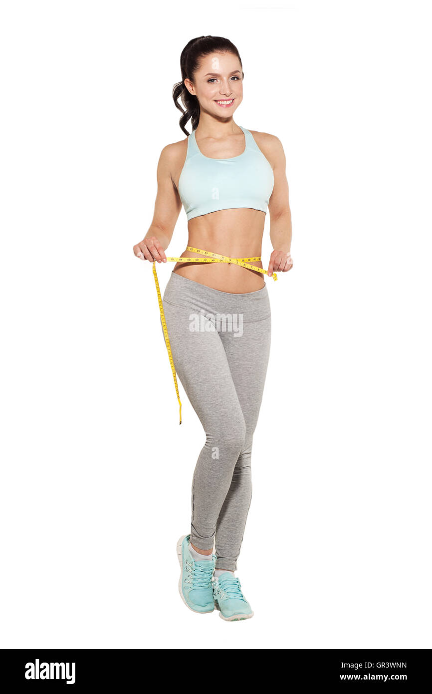 weight loss, sports girl measuring her waist, training in the gym, workout abdominals Stock Photo