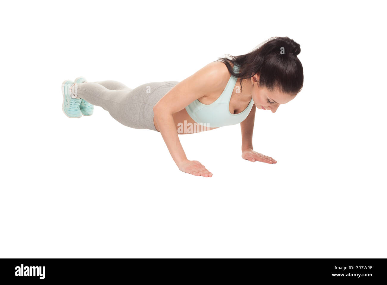 athletic woman doing push-ups on a white background. Fitness model with a beautiful, athletic body Stock Photo