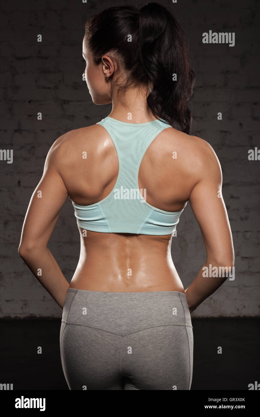the back of sports women on training, fitness girl with muscular