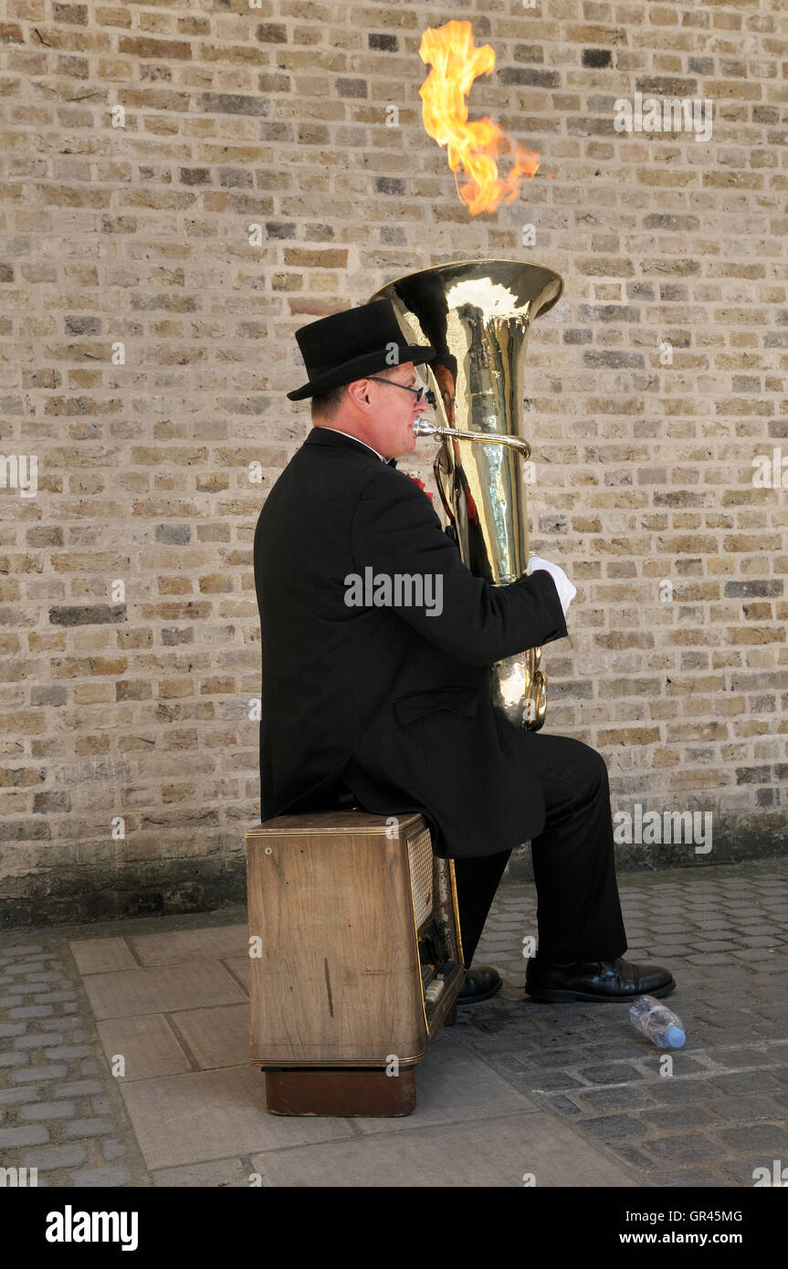 Busker known as 'Fire Tuba' playing his modified musical instrument in a unique street performance on the South Bank, London, UK Stock Photo