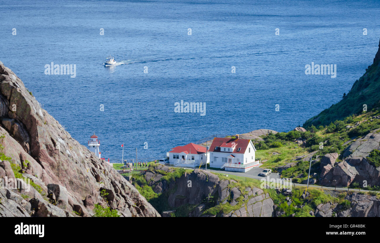 People & tourists visiting lighthouse on the cliffs of National Historic Site of Canada, Fort Amherst in St John's Newfoundland. Stock Photo