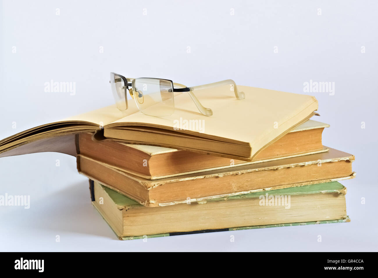 Closeup of several old books and glasses on bright background Stock Photo