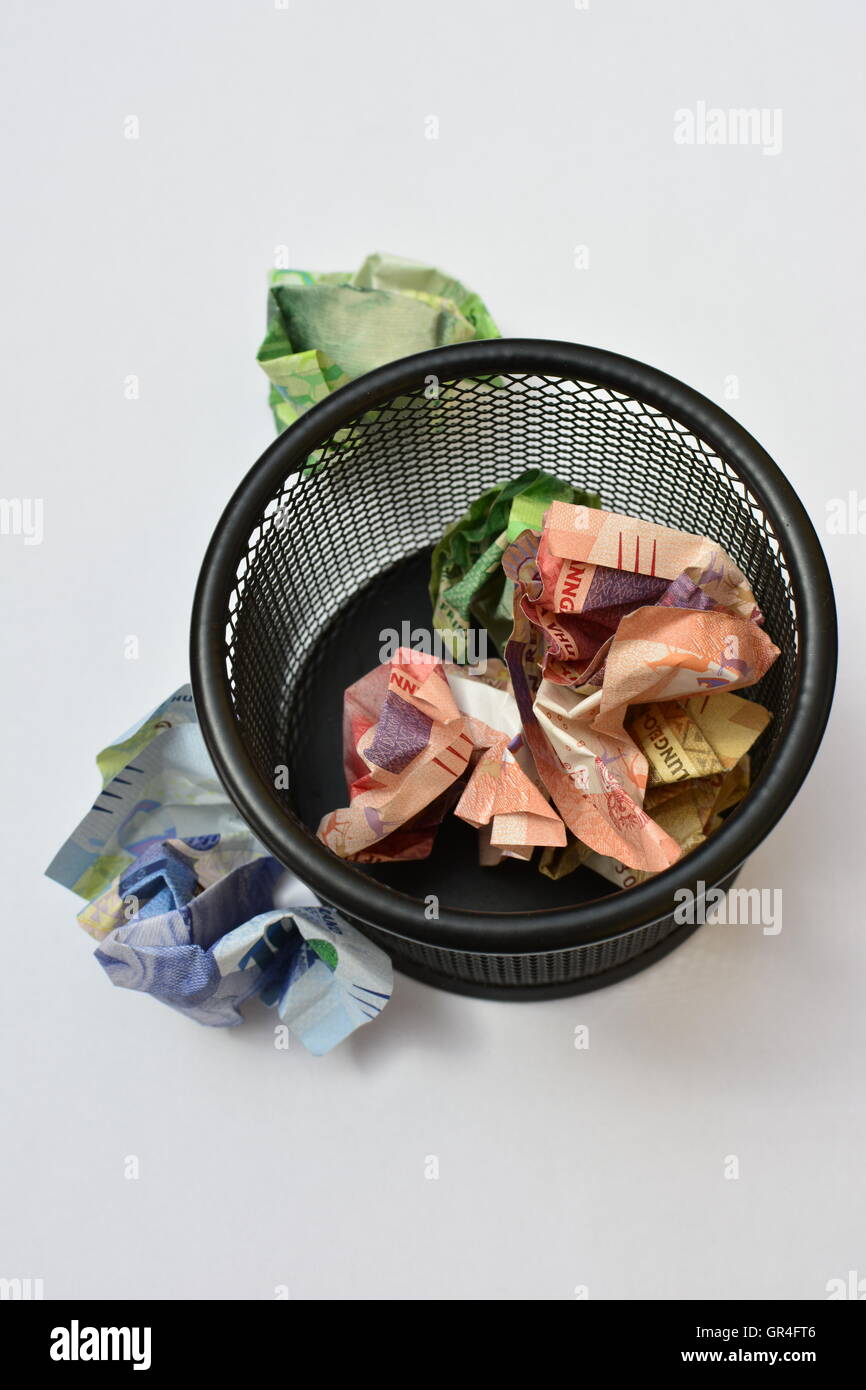 Wasting money concept. Throwing money away. Money in wastepaper basket