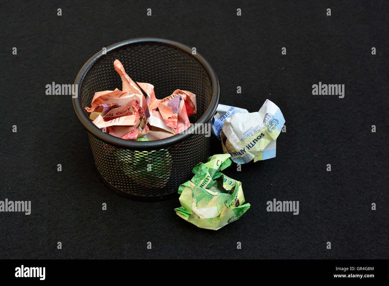 Wasting money concept. Throwing money away. Money in wastepaper basket