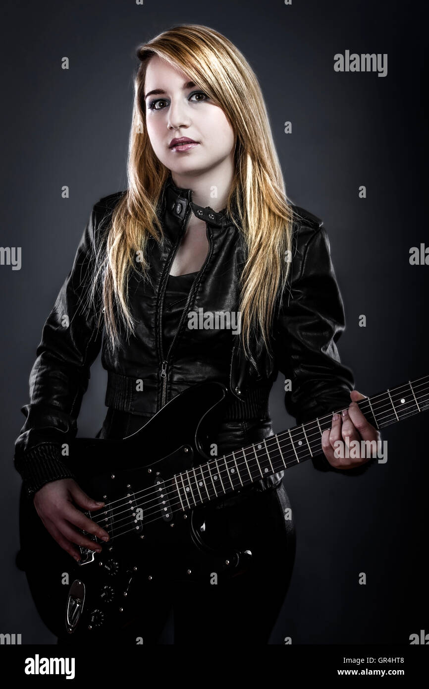 Teenager holding a black electric guitar Stock Photo - Alamy