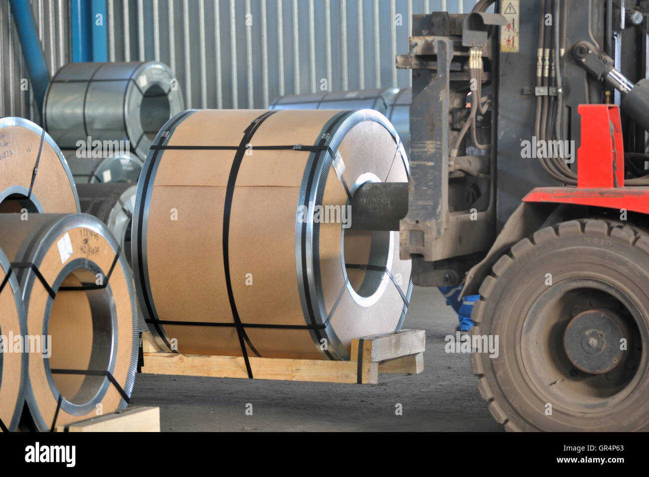 Forklift with rolls of steel sheet Stock Photo