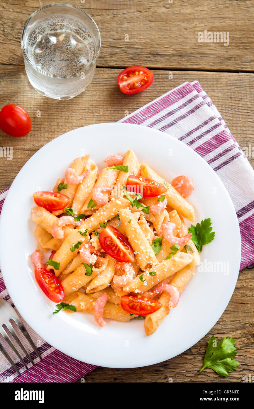 Penne pasta with shrimps, tomato sauce, parsley and grated parmesan