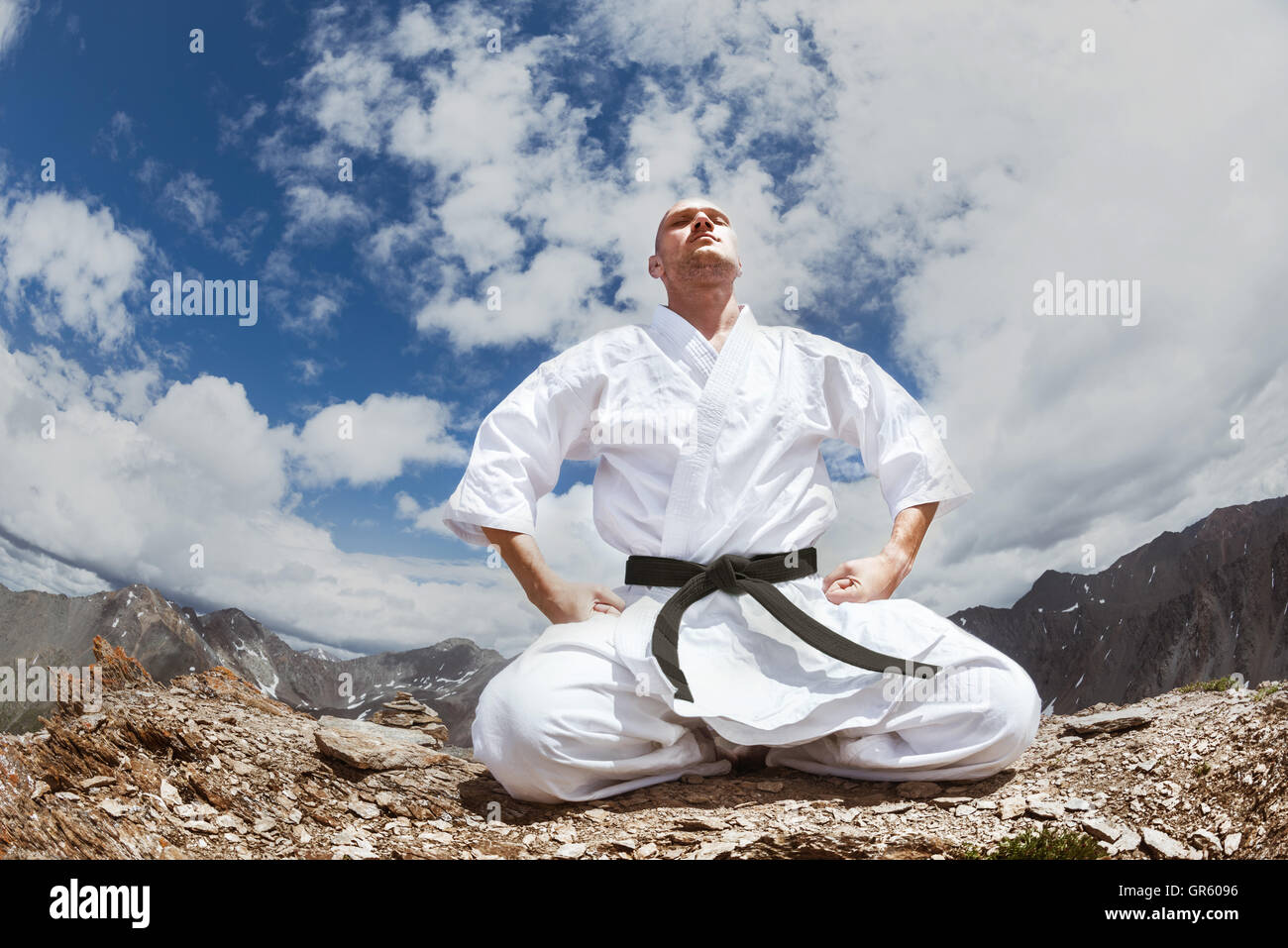 Karate man sits in yoga pose Stock Photo