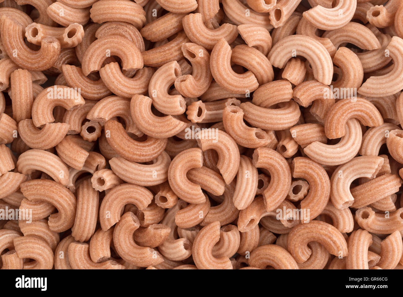 A very close view of red rice elbow shaped pasta. Stock Photo