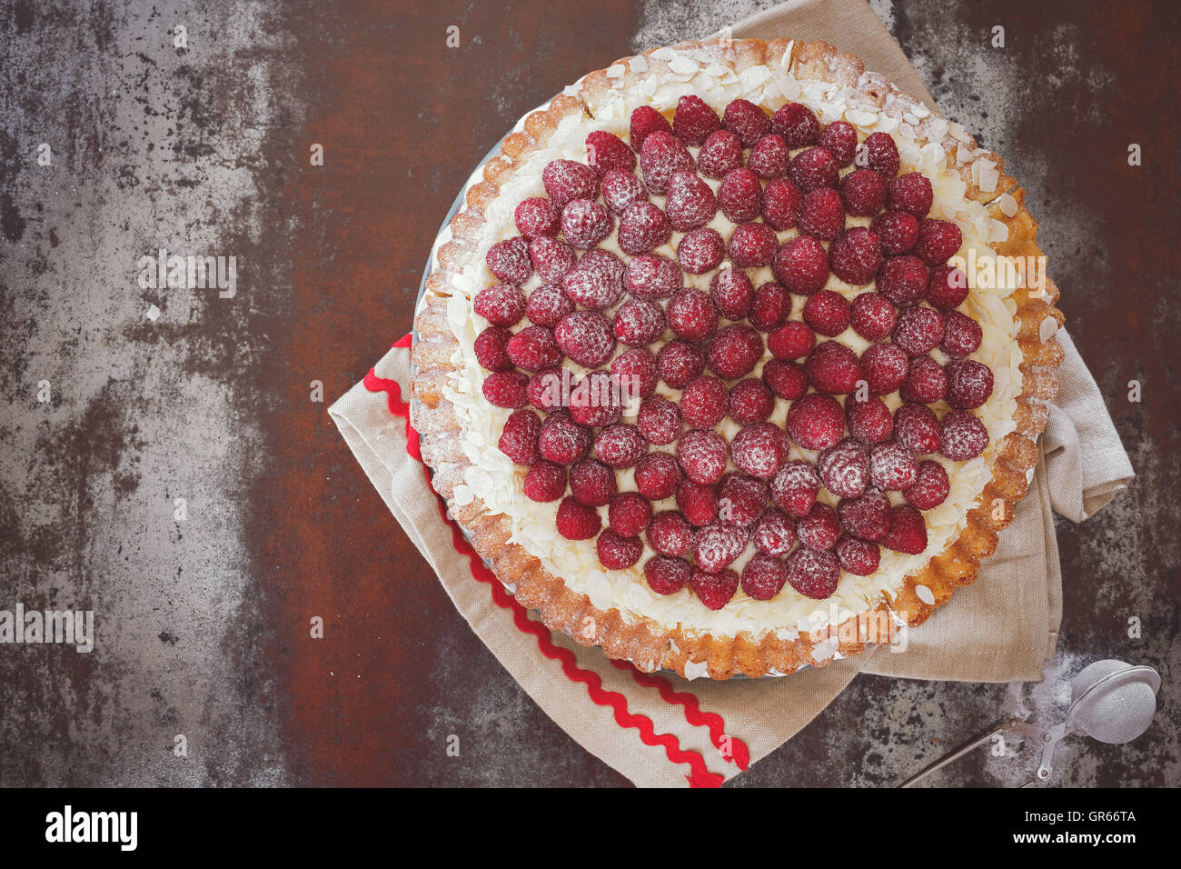 Raspberry tart with vanilla cream and icing sugar. Macro, selective focus, vintage toned image, blank space Stock Photo