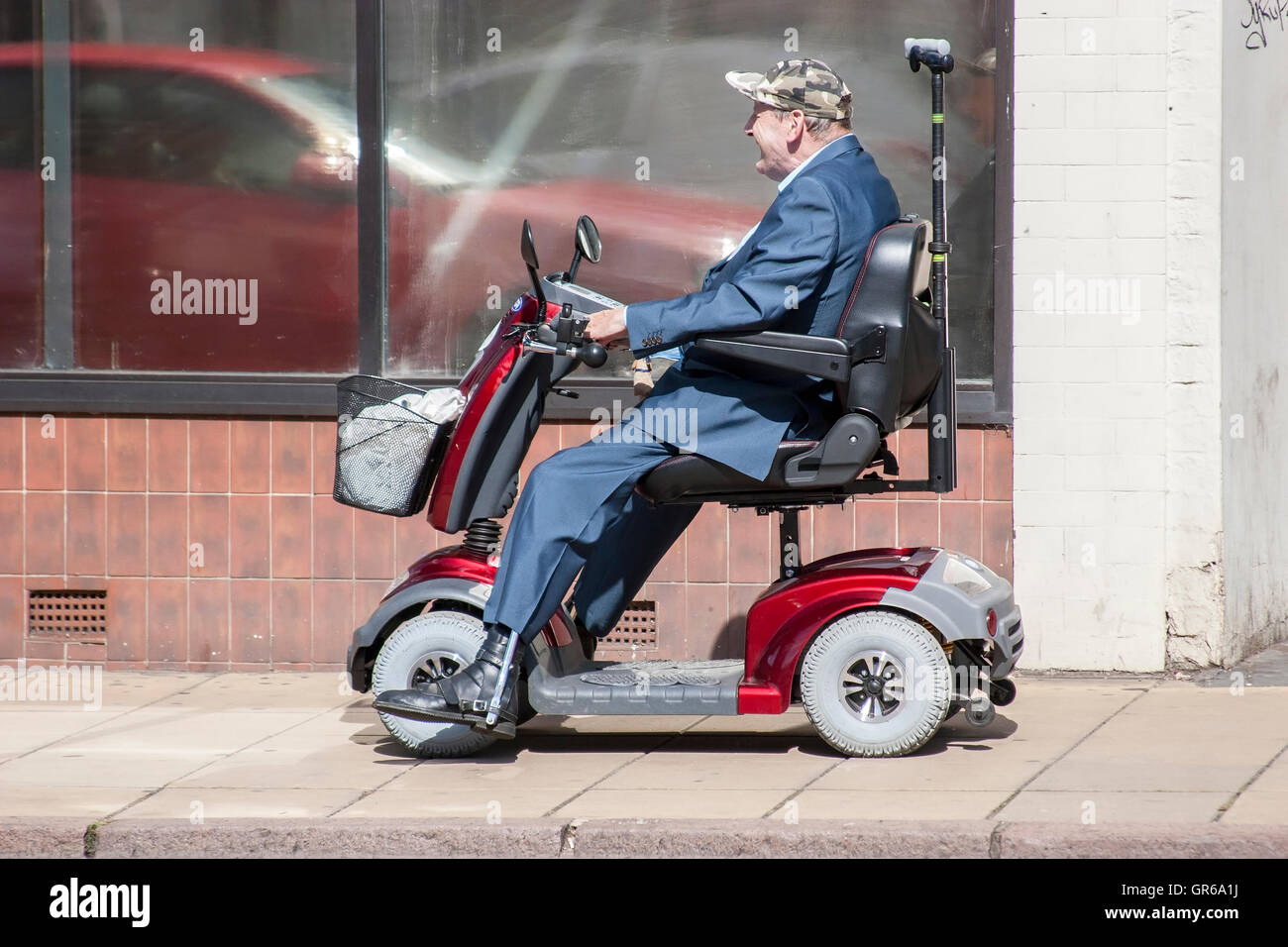 Gent on mobility scooter in Wellingborough rd, Northampton Stock Photo