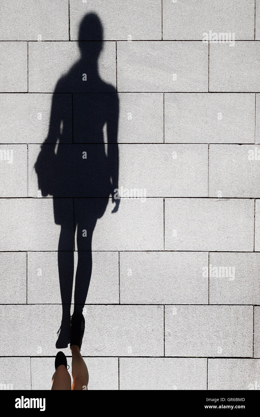 shadow of a woman walking on pedestrian street Stock Photo