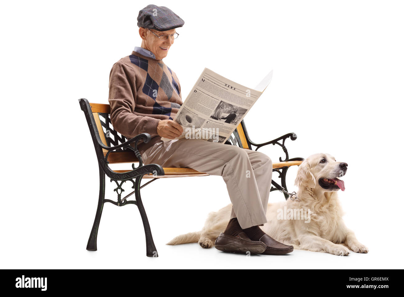 Senior man sitting on a bench and reading a newspaper with his dog ...