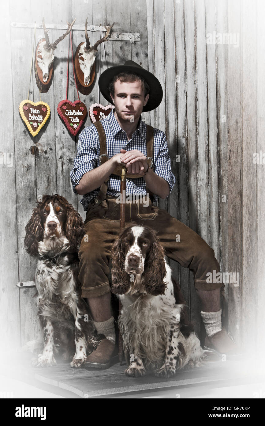 Young Man In Leather Pants With Two Dogs Stock Photo