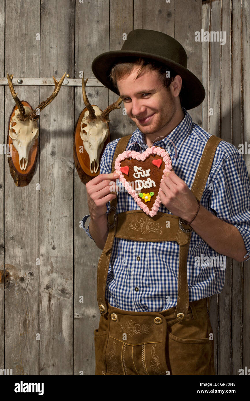 Young Man In Leather Pants With Gingerbread Stock Photo