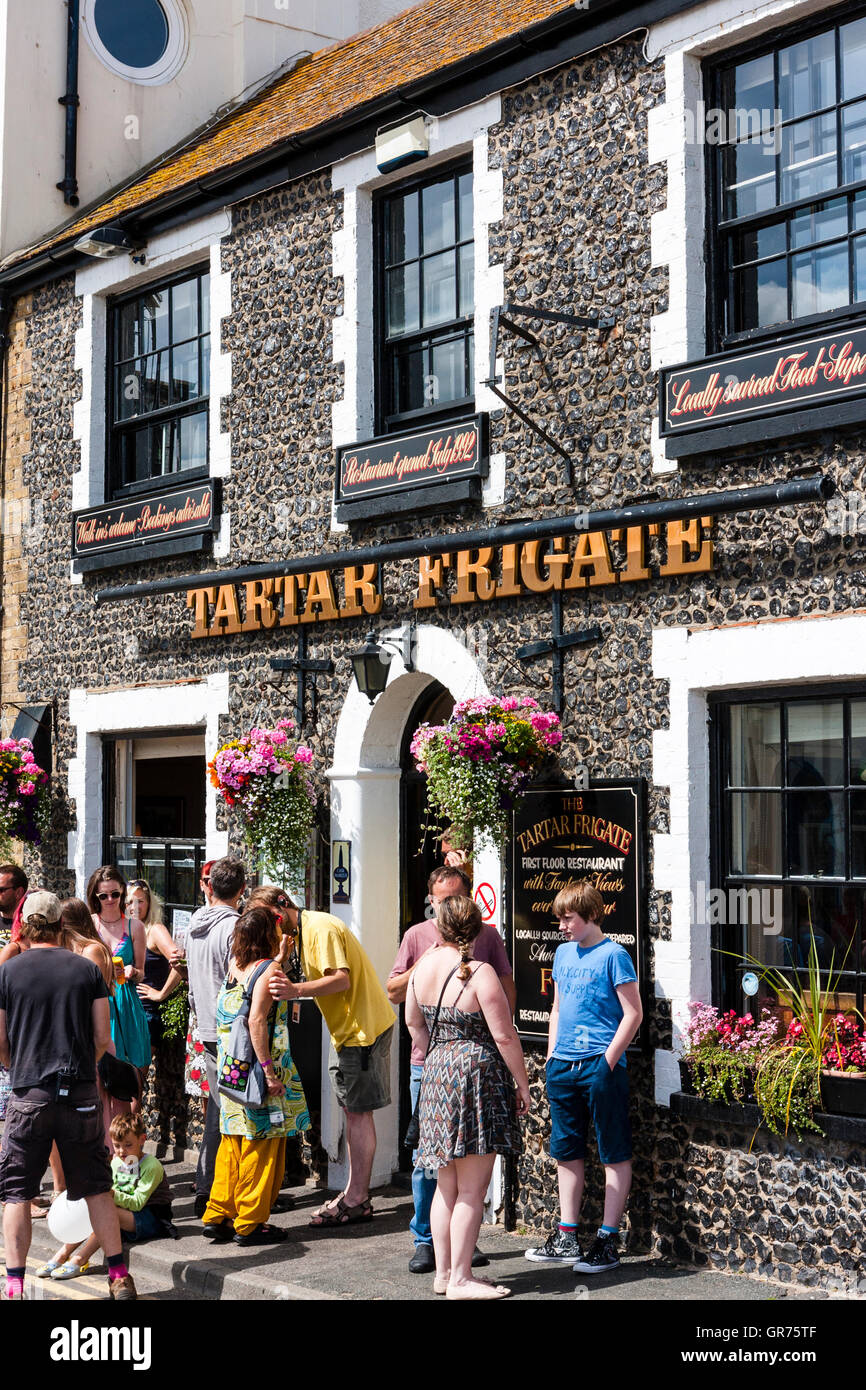 England, Broadstairs. Tartar Frigate popular bar and restaurant, with group of teenagers standing outside and chatting on a hot summer's day. Stock Photo