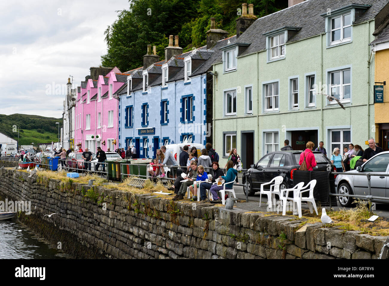 Visitors In Front Of Colourful Houses Along The Harbour Waterfront, Portree, Isle Of Skye, Scotland, Uk Stock Photo
