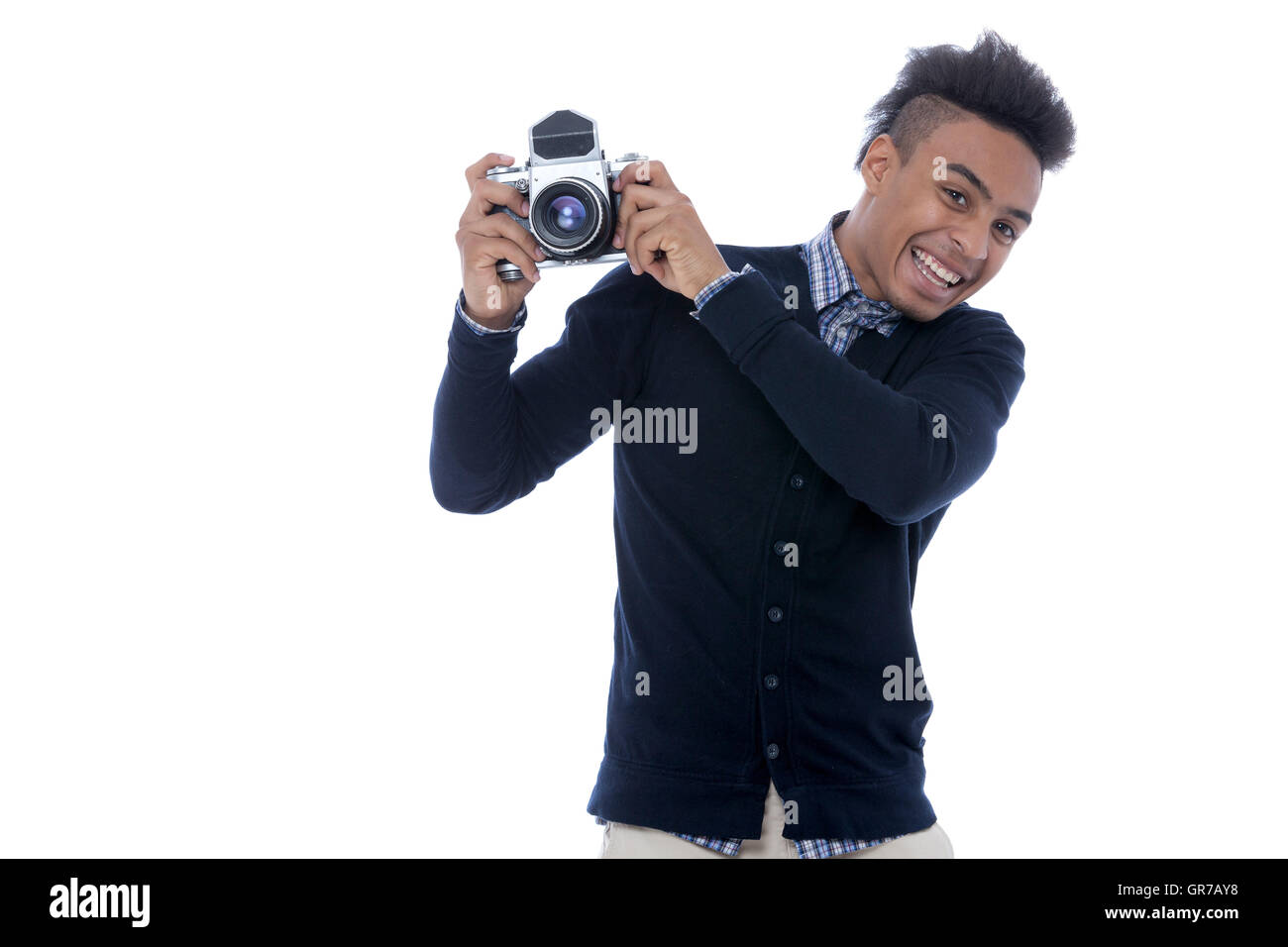 Young african man holding an old camera and being happy on the pictures taken. Stock Photo