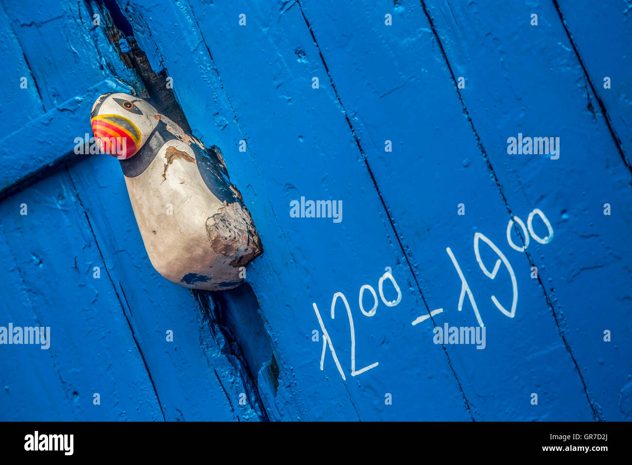 Riss In Einer Holztüre, Wurde Behelfsmäßig Durch Eine Hölzerne Papageientaucherfigur Verstopft Stock Photo